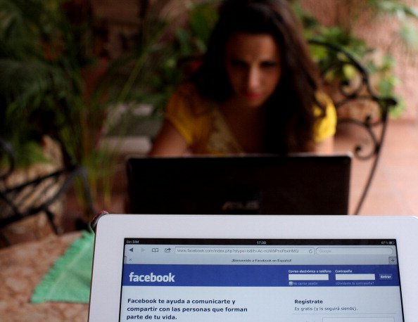 A tablet displays the homepage of Facebo