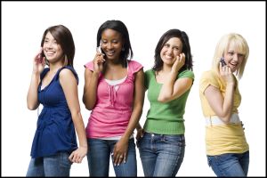 Four women talking on cell phones smiling