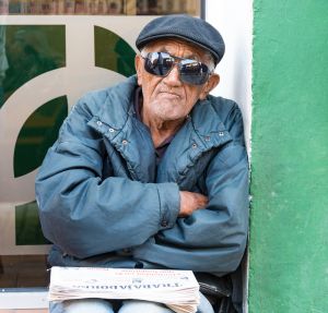 Cuban senior selling Trabajadores newspaper. Elders make...