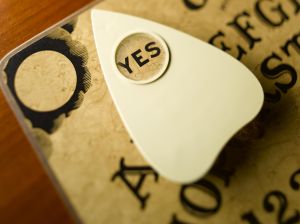 Planchette on talking board highlighting word yes, close-up (differential focus)