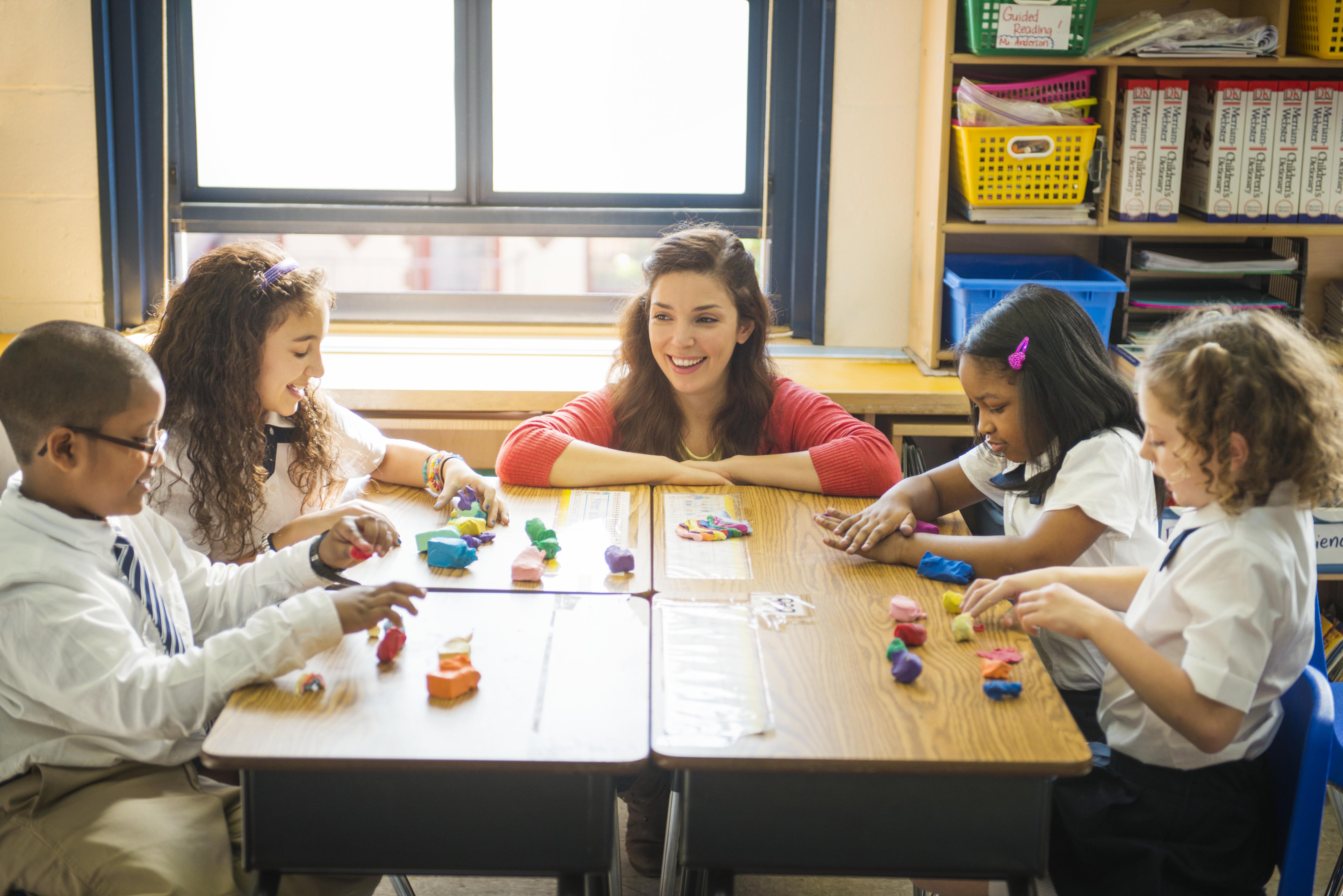 Teacher Helping Students with Arts and Crafts
