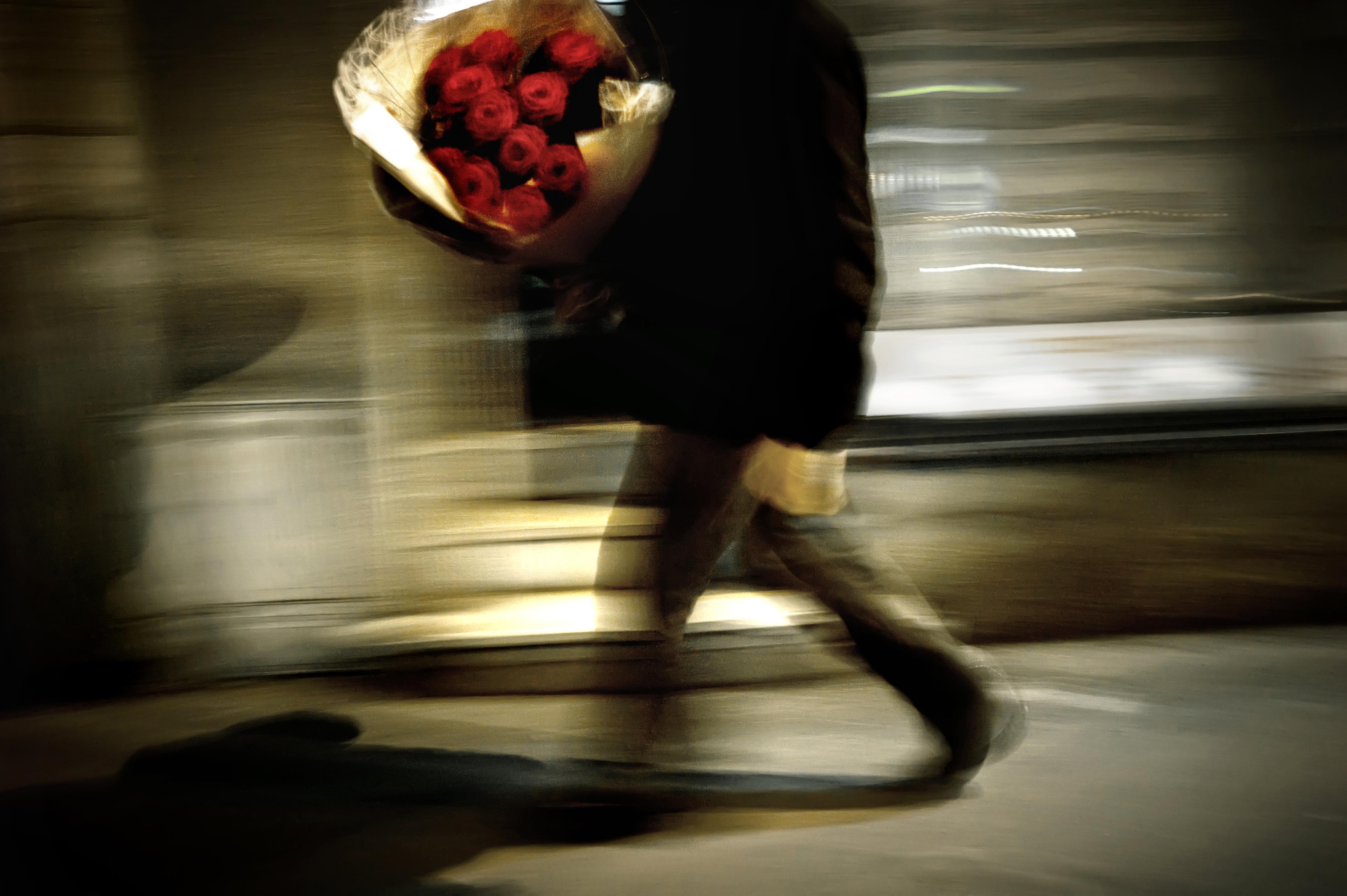 A man carries a bouquet of red roses dur
