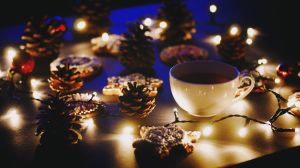 Close-Up Of Coffee Cup And Gingerbread Cookies Amidst Illuminated Christmas Lights